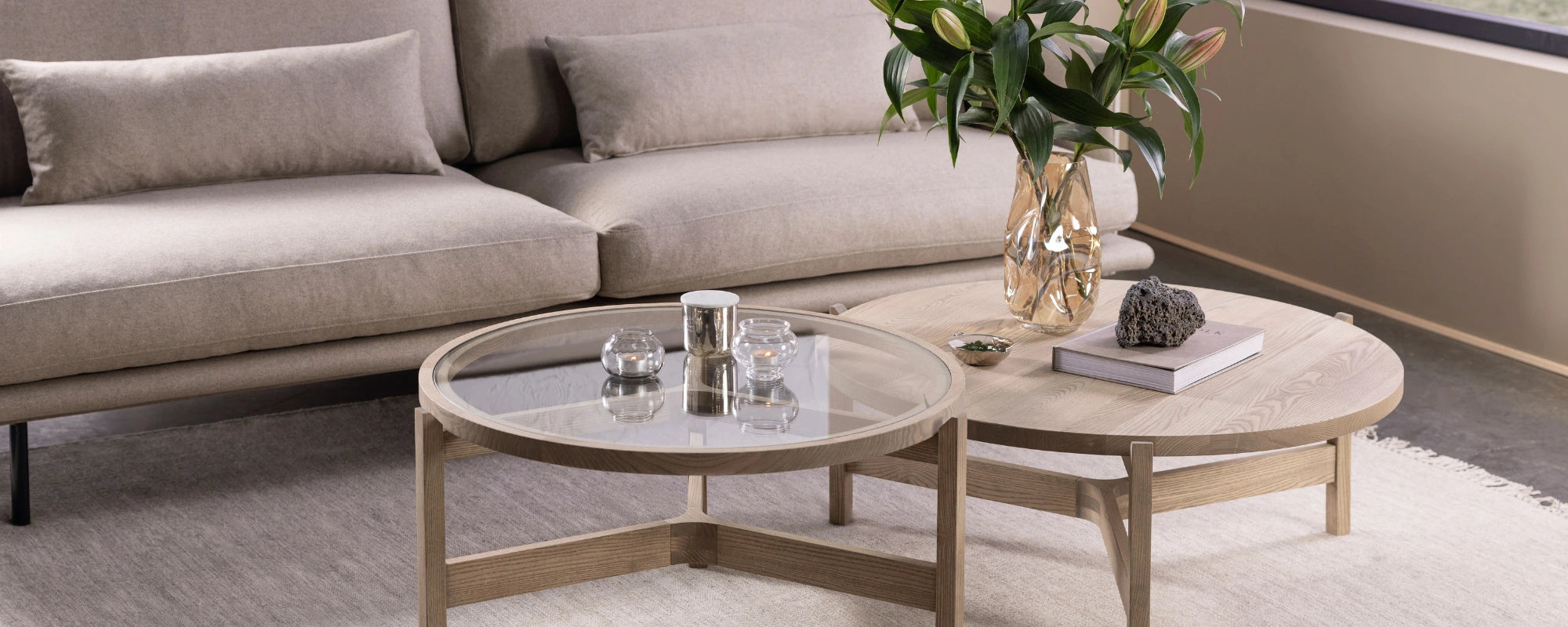 Round wooden coffee table with decorative items in a living room setting.