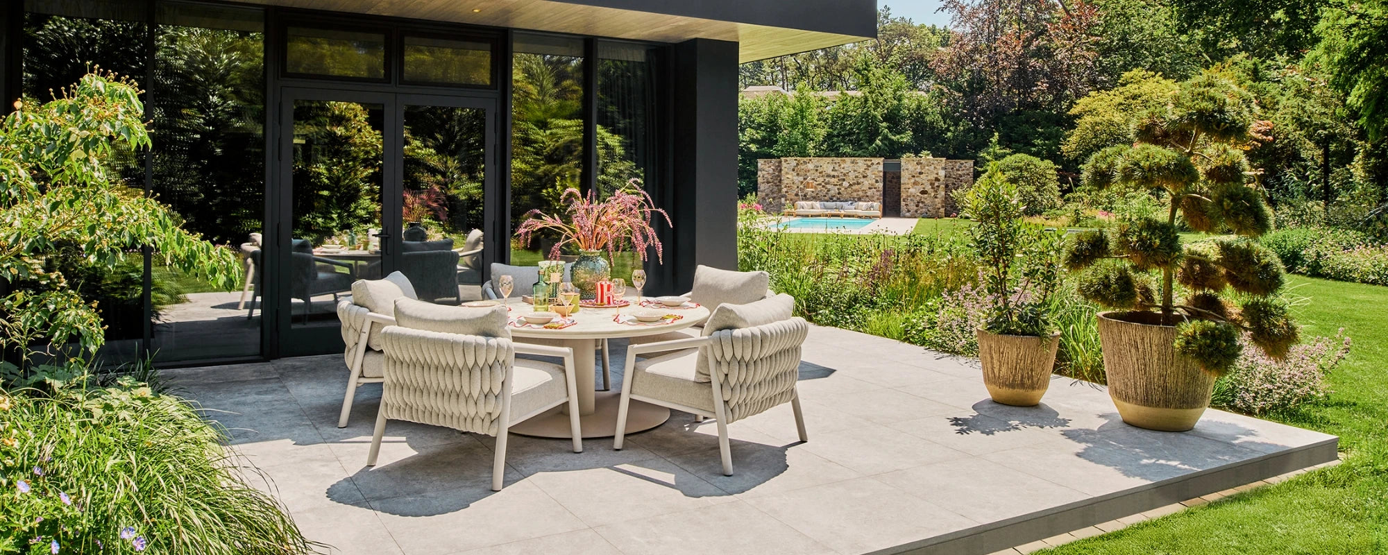 Outdoor patio set with low table and chairs in a garden setting