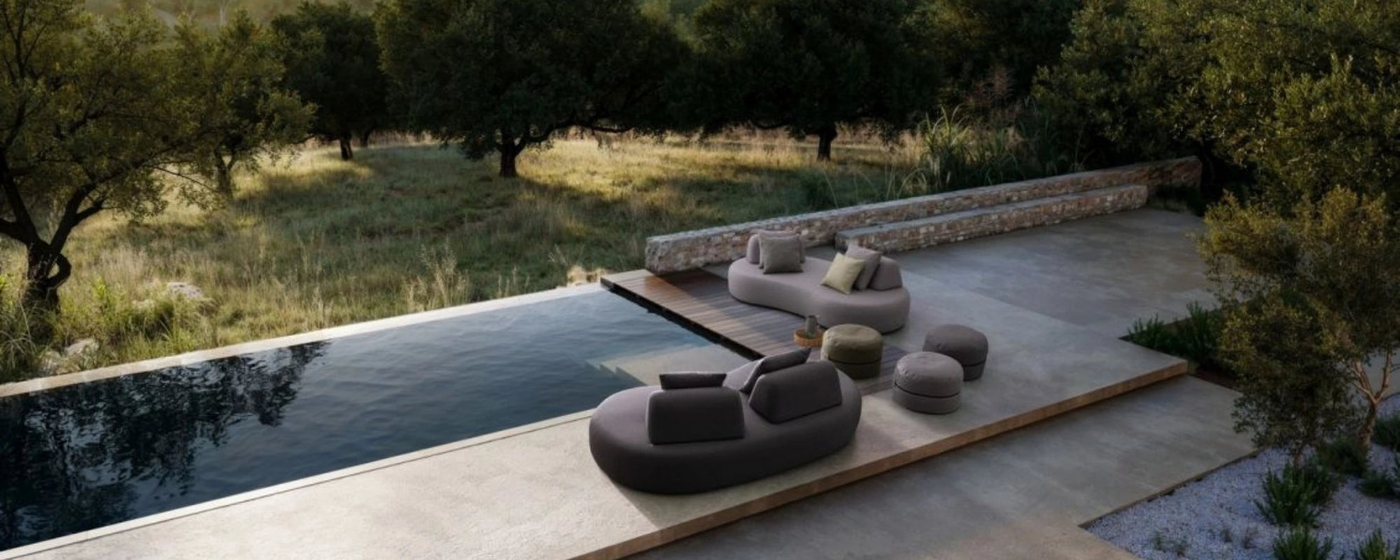 Outdoor seating area with a pool and greenery in the background